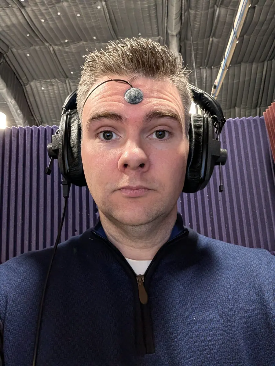 Matthew McMahon recording in a voice-over booth wearing headphones